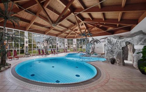 a swimming pool in a resort with a large building at Lisi Family Hotel in Reith bei Kitzbühel