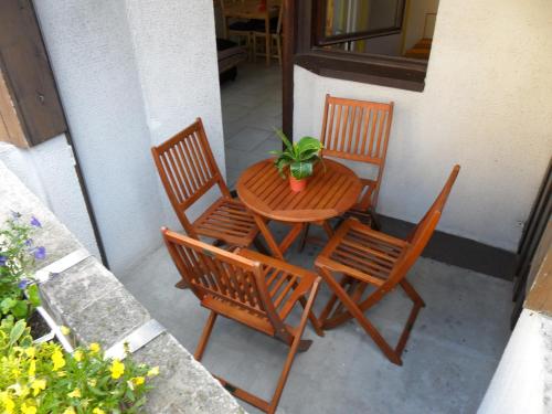 un tavolo e sedie con una pianta in vaso su un patio di CHAMONIX CENTRE 2 Pièces Balcon Vue MONT BLANC a Chamonix-Mont-Blanc