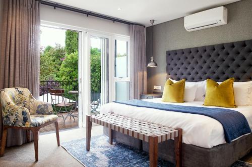 a bedroom with a king sized bed and a balcony at Bonne Esperance Boutique Guest House in Stellenbosch