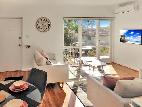 sala de estar con reloj en la pared en Glen Iris, Quiet Boutique 2 bedroom Netflix, WIFI, Parking, Free Wine en Melbourne