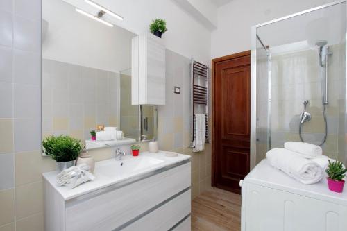 uma casa de banho com um lavatório branco e um espelho. em Martino Delightful Apartment em Roma