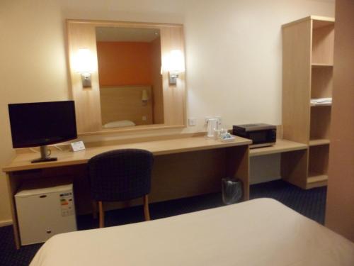 a room with a desk with a computer and a mirror at Metro Inns Huddersfield in Huddersfield