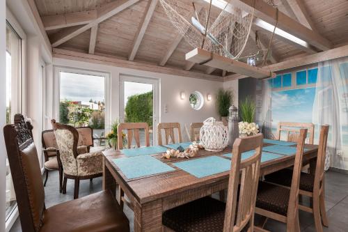 a dining room with a wooden table and chairs at Willa Ewa in Łeba