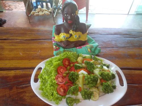 a plate of food with a plate of broccoli and tomatoes at Bistrô Pousada Savacipó in Serra do Cipo