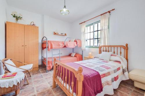 a bedroom with a bed and a crib and a chair at Viv Vac La Casita del Viejo in Guía de Isora