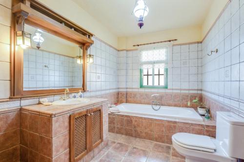 a bathroom with a tub and a sink and a toilet at Viv Vac La Casita del Viejo in Guía de Isora