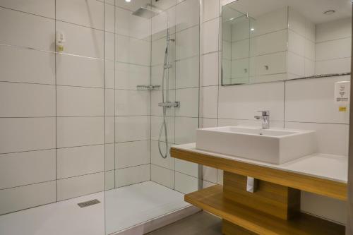 een witte badkamer met een wastafel en een douche bij Hotel Restaurant San Lucianu in Moriani Plage