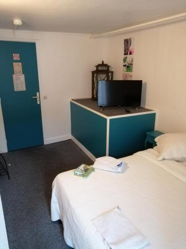 a room with two beds and a flat screen tv at le relais in Fontenay-Trésigny