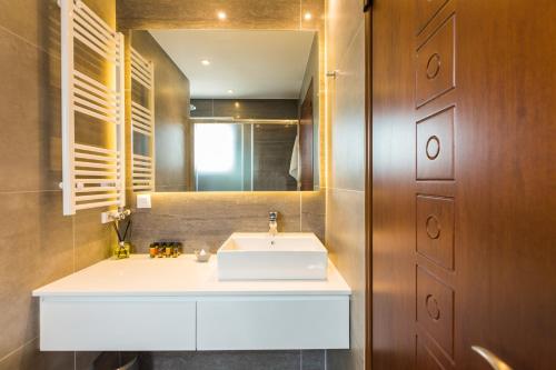 a bathroom with a white sink and a mirror at Villa Aelia I Modern & Ideal for large groups in Galatás