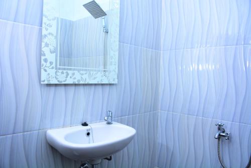 een witte badkamer met een wastafel en een spiegel bij Sapu Nyapah Losmen Syariah Tanjung Setia in Biha
