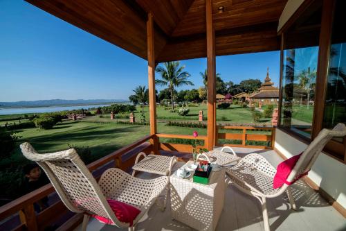 a table and chairs on a porch with a view of the water at Bagan Thiripyitsaya Sanctuary Resort in Bagan
