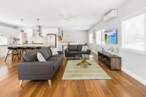 a living room with a couch and a table at HALE KUPA Rye Beach House Spa Table Tennis in Rye
