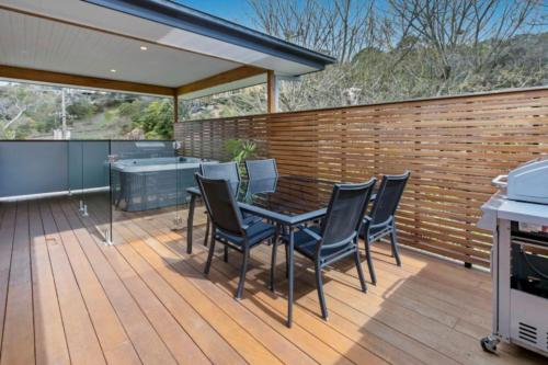 a patio with a table and chairs on a deck at HALE KUPA Rye Beach House Spa Table Tennis in Rye