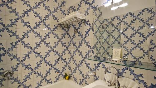 a bathroom with a blue and white tiled wall at Grand Hotel Aminta in Sorrento