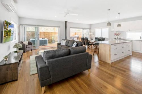 a large living room with a couch and a kitchen at HALE KUPA Rye Beach House Spa Table Tennis in Rye