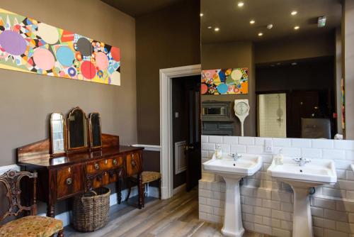 a bathroom with two sinks and a mirror at City Centre Mansion Sleeping 1 to 23 in Cardiff