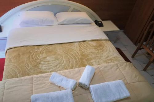 Una cama con dos toallas encima. en Hotel Elena en Edessa