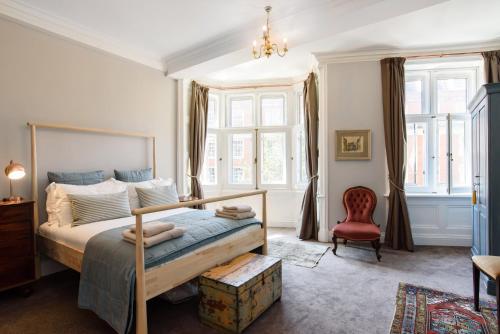 a bedroom with a bed and a red chair at City Centre Mansion Sleeping 1 to 23 in Cardiff