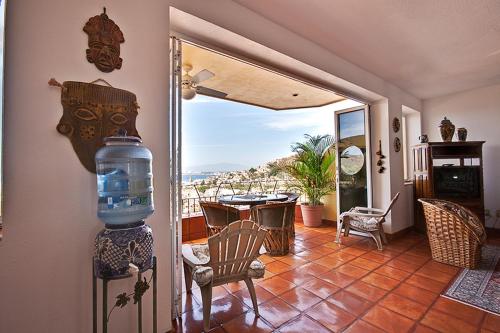 een woonkamer met uitzicht op een tafel en stoelen bij Casa Isabel a Boutique Hilltop Inn in Puerto Vallarta