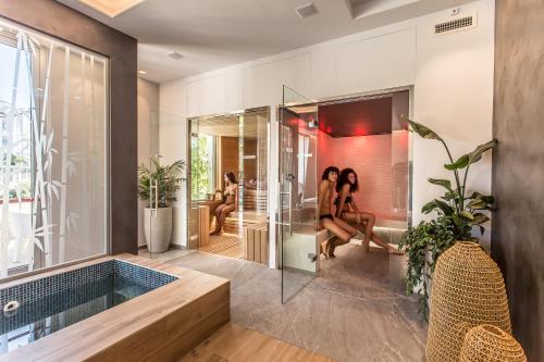 Dos mujeres sentadas en un baño con bañera en Park Hotel Morigi Garden & Spa, en Gatteo a Mare