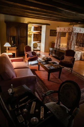 a living room with a couch and a table at Manoir Du Bois Noblet in Louerre
