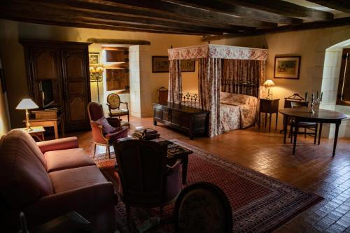 a living room with a bedroom with a bed and a table at Manoir Du Bois Noblet in Louerre