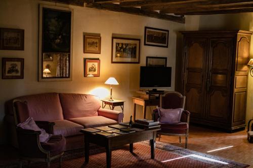 a living room with a couch and a coffee table at Manoir Du Bois Noblet in Louerre