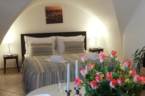 a bedroom with a bed with two tables and flowers at St. George Apartments in Prague