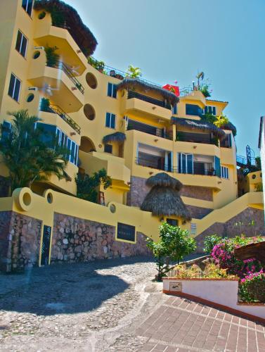 a large yellow building with a pathway in front of it at Casa Isabel a Boutique Hilltop Inn in Puerto Vallarta