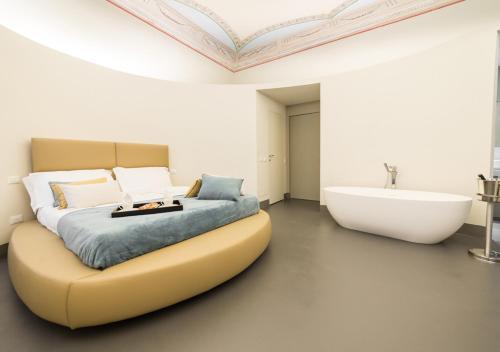a bedroom with a large bed and a bath tub at LUCUS Exclusive Bed and Breakfast in Lucca