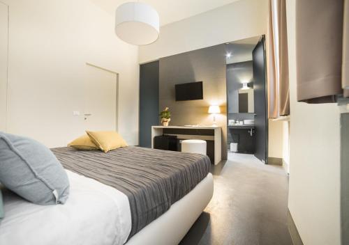 a bedroom with a bed and a desk in it at LUCUS Exclusive Bed and Breakfast in Lucca
