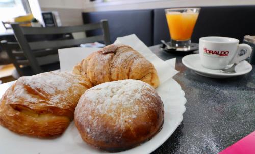 tre pasticcini su un piatto bianco su un tavolo di BnB Naples a Napoli