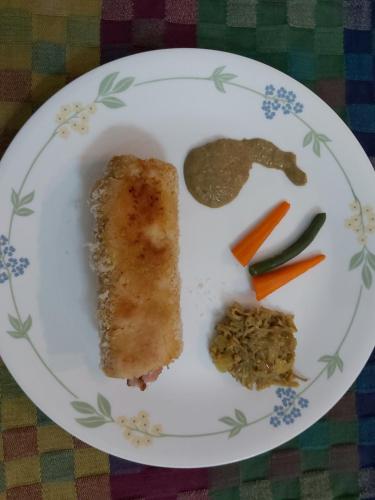 a plate of food with a piece of fish and vegetables at Tarana Homestay in Gonikoppal