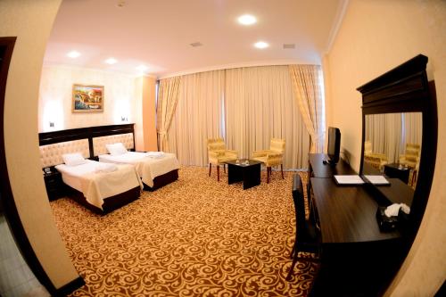 a hotel room with a bedroom with two beds at New Baku Hotel in Baku