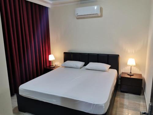 een slaapkamer met een bed met 2 nachtkastjes en 2 lampen bij Margarita Hotel in Amman