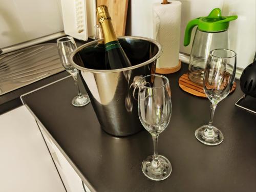 three wine glasses and a bucket on a kitchen counter at Sun Beach 89 in Caleta De Fuste