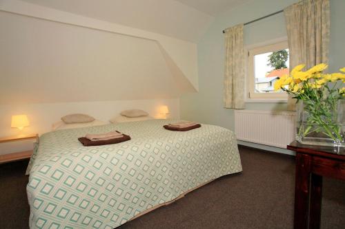 een slaapkamer met een bed en een vaas met bloemen bij U Kašny in Kašperské Hory