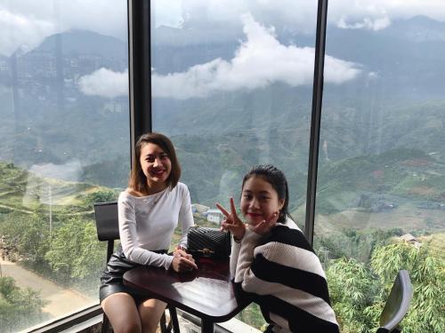 two girls sitting at a table in a room with a view at Sapa Valley view hotel in Sa Pa
