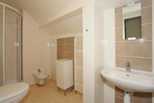 La salle de bains blanche est pourvue d'un lavabo et de toilettes. dans l'établissement U Kašny, à Kašperské Hory