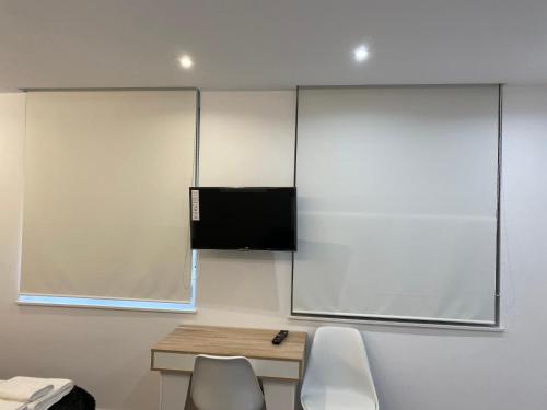 uma sala de aula com um ecrã e duas cadeiras e uma secretária em WILLMARK 2 em Salamanca