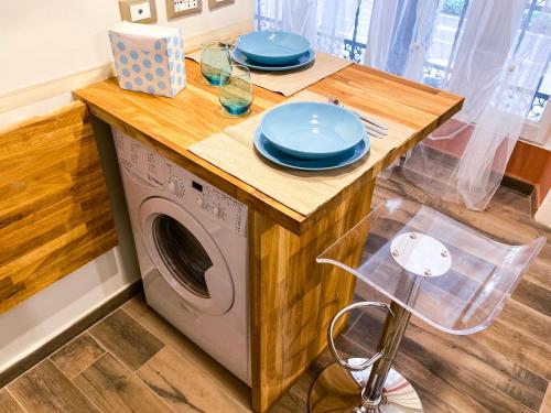 uma cozinha com uma mesa e uma máquina de lavar roupa em A 2 PASSI DAL CENTRO em Gênova