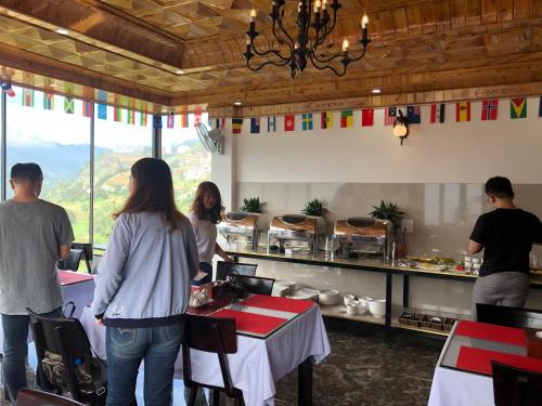 a group of people standing in a kitchen with a table at Sapa Valley view hotel in Sa Pa