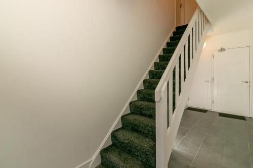 a staircase in a house with green carpet at Denby Lodge in Letchworth