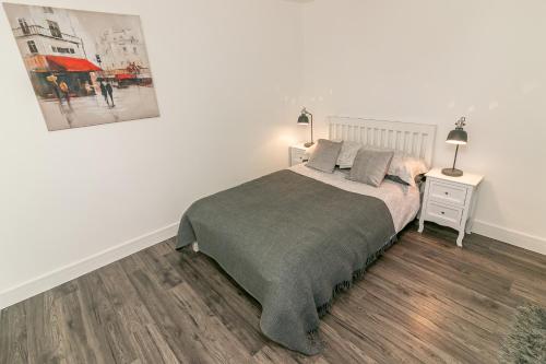 a bedroom with a bed and a picture on the wall at Denby Lodge in Letchworth