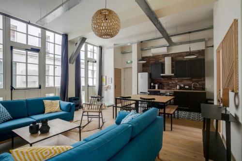 a living room with a blue couch and a table at Lofts Philippe-Auguste in Paris