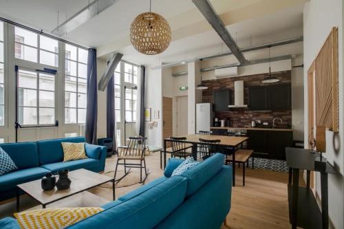 un salon avec un canapé bleu et une table dans l'établissement Lofts Philippe-Auguste, à Paris