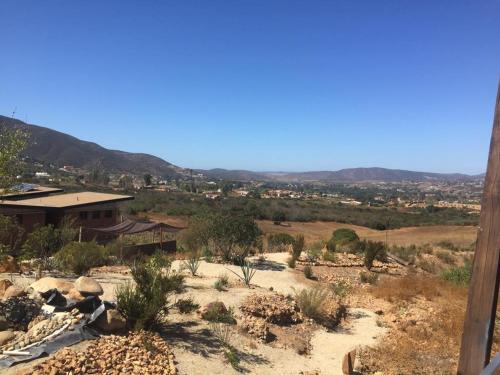 バジェ・デ・グアダルーペにあるSuites Nativo - Beautiful Vineyard & Valley Viewの遠くの家を持つ砂漠の景色