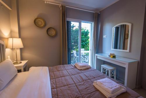 a bedroom with a bed and a window and a table at Regalo Apartments in Lygia