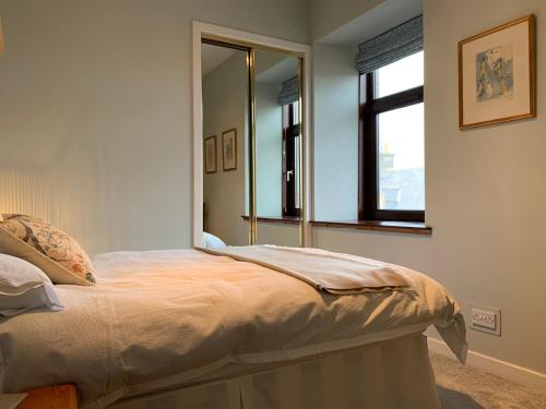 een slaapkamer met een bed en een grote spiegel bij Hayfield Apartment in Lossiemouth