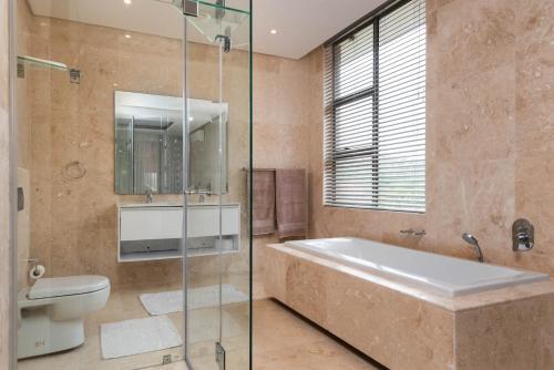 a bathroom with a tub and a toilet and a shower at Zimbali Coastal Resort - ZKY1 - 3 Bedroom Apartment in Ballito